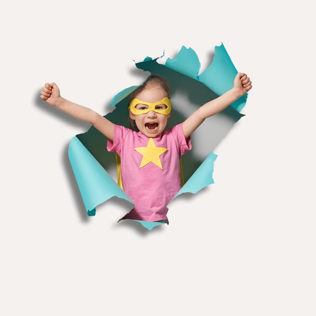 Child in a superhero costume breaking through paper backdrop.