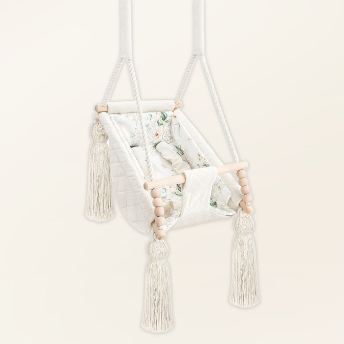 Baby Hammock Beige, in velvet, three-quarter view with tassels, wooden beads and padded seat