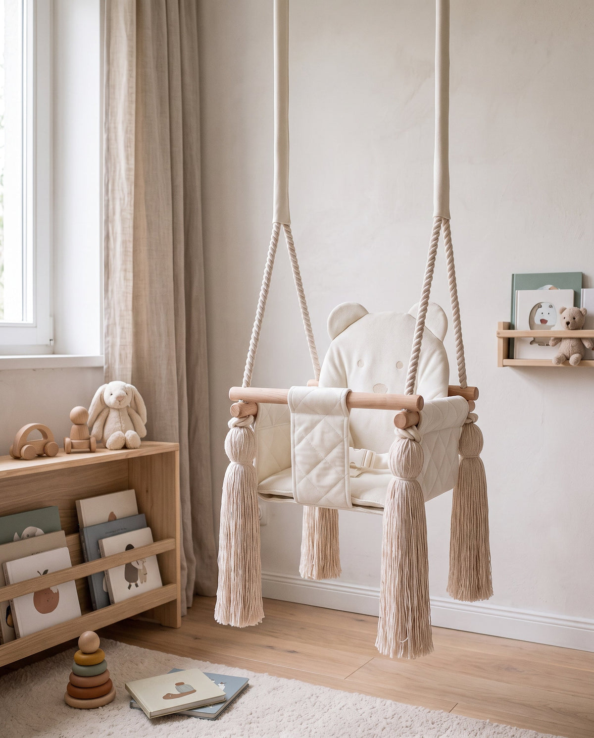 Velvet baby swing with bear motif in beige in a bright children's room